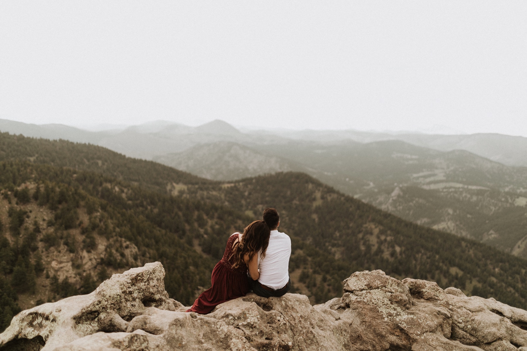 Jason and his wife sitting together and looking across a mountain landscape